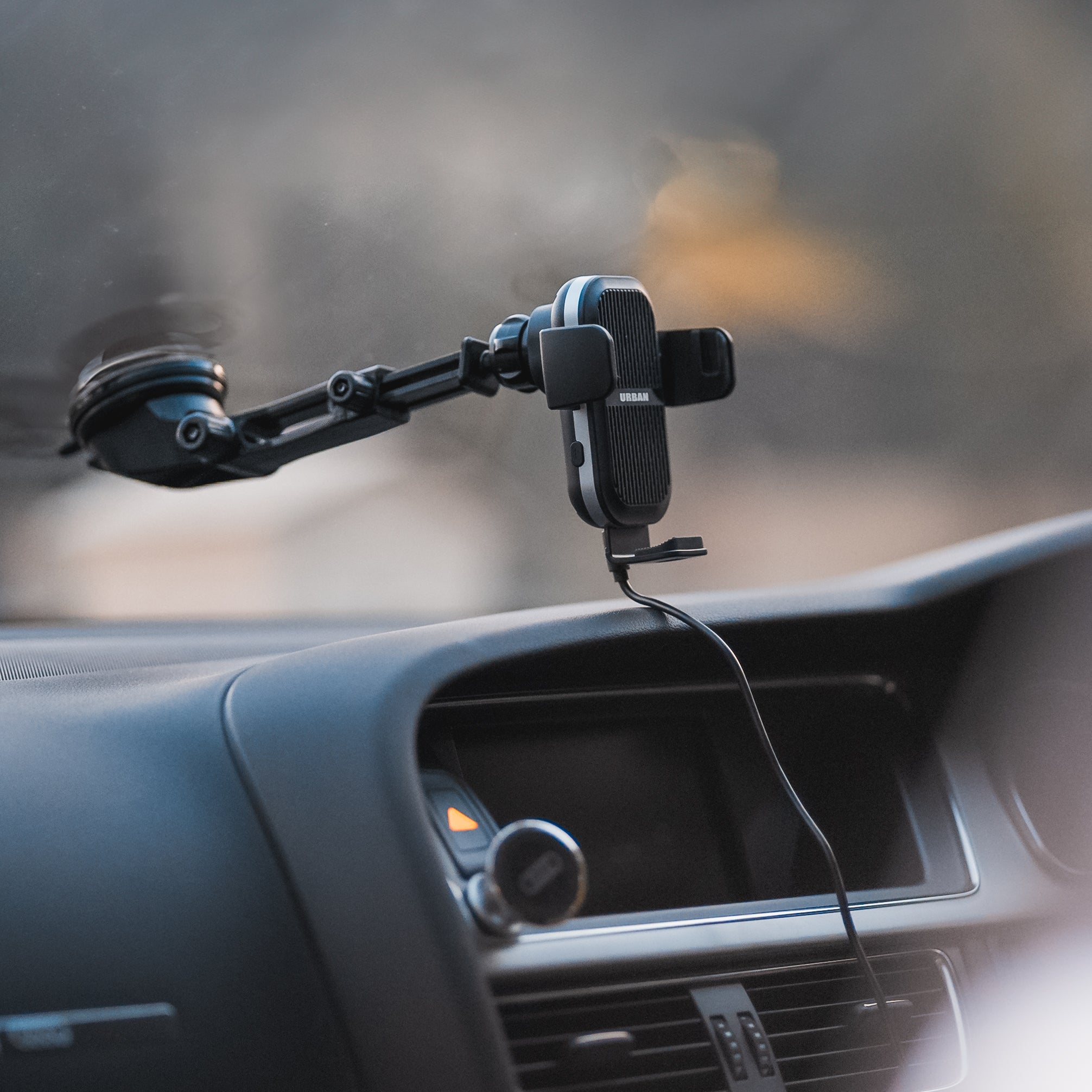 Auto15 Pro Cooling Wireless Car Charger Kit by Urban mounted on a car dashboard holder with a blurred background.